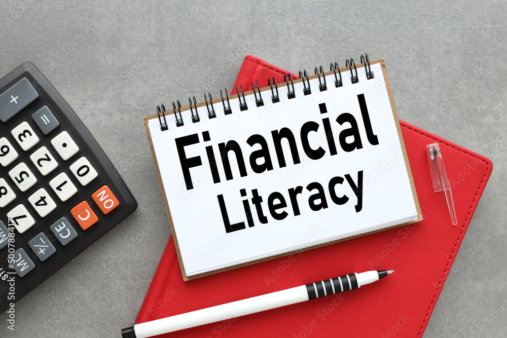 Poster financial literacy -open notepad with text on red notepad near calculator