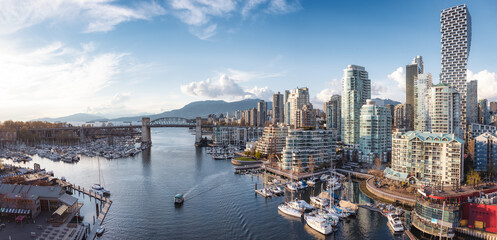 Panoramic Aerial View of Granville Island in False Creek with modern city skyline and mountains in...