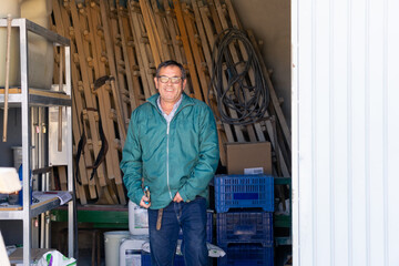 Smiling farmer walks through his farmland's warehouse