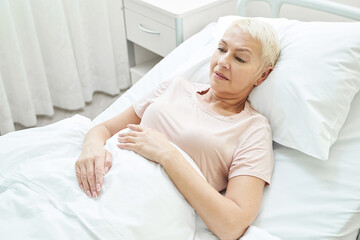 Obraz na płótnie Canvas Sick elderly patient in bed of medical center