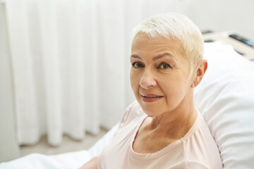 Senior woman in health care facility staring at camera