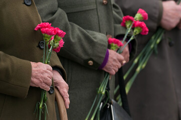 veterans hold flowers in their hands on the day of remembrance of those killed in the war