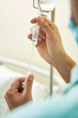 Medical professional controlling drip of IV line
