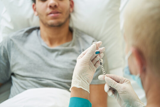 Medical person drawing up a vaccine to syringe - Powered by Adobe