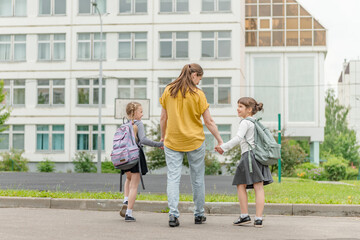two little happy girl with mom go to school education concept. High quality photo