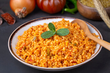 Traditional turkish bulgur pilaf with tomato sause in plate (Turkish name; meyhane pilavi)