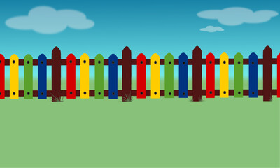 Colorful children's fence with blue sky and grass background