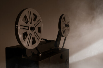 Obraz premium Old vintage 8mm projector with film reels and film frames. Copy space. Selective focus.