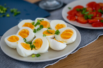 homemade breakfast, yellow cheese with holes, small sliced tomatoes, cottage cheese, egg paste, eggs, chives, tea, orange, carrot and grapefruit juice in wine glasses, black tableware.