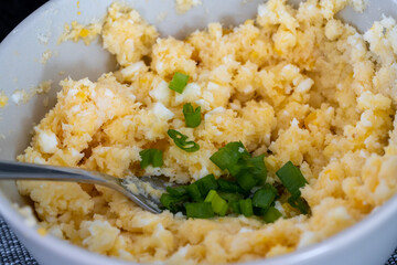 homemade breakfast, yellow cheese with holes, small sliced tomatoes, cottage cheese, egg paste, eggs, chives, tea, orange, carrot and grapefruit juice in wine glasses, black tableware.