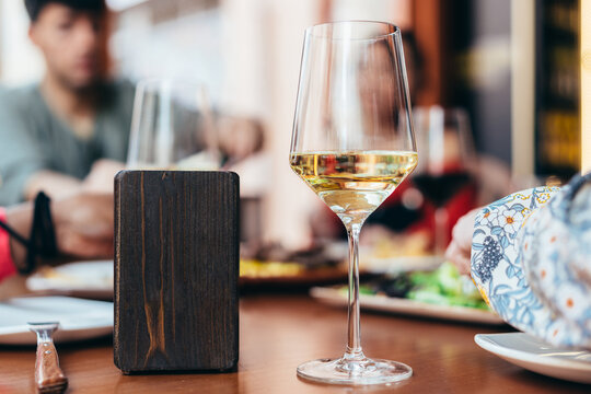 glass of white wine next to a napkin holder