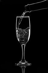 Champagne bottle and glass silhouette, isolated black background.