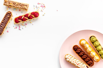 Top view of sweet bakery eclairs with color topping