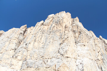 Fototapeta na wymiar Peak of mountain massif in a sunny day with blue sky on background. Italian Alps.