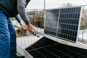 Close up of man holding solar panel. Eco concept alternative energy
