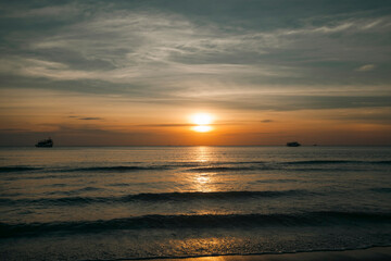 Fototapeta na wymiar A beautiful sunset on a tropical sea beach in Thailand.