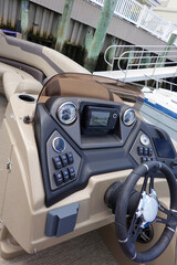 Close up of the dashboard control panel and steering wheel of a boat