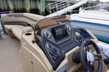 Close up of the dashboard control panel and steering wheel of a boat