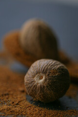 Nutmeg and nutmeg powder in a wooden spoon on a slate background.Spices and condiments.Nutmeg close-up on a dark background. Dark mood.