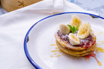 pancake with bananas and raspberry jam on plate
