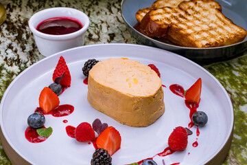 terrine de foie gras on grey plate with berries macro close up