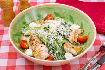 Salad caesar with chicken on green plate