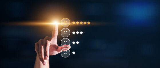 hand pressing smartphone with smiley face icon and five star on visual screen for positive feedback.
