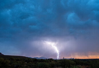 Naklejka na ściany i meble Monsoon lightning storm in the desert