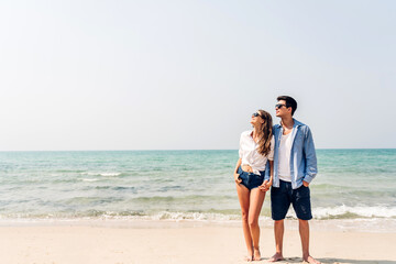 Vacation romantic love young happy smile couple in honeymoon travel holiday trip standing on sand at blue sky sea beach having fun and relaxing together on tropical beach.Summer travel