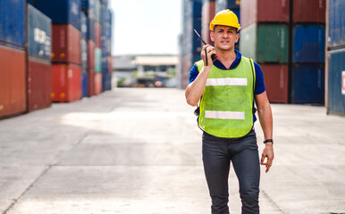 Professional engineer container cargo foreman in helmets working standing and using walkie talkie checking stock into container for loading.logistic transport and business industry export