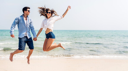 Vacation romantic love young happy smile couple in honeymoon travel holiday trip standing on sand at blue sky sea beach having fun and relaxing together on tropical beach.Summer travel - Powered by Adobe