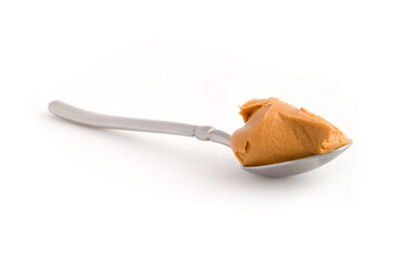 Scoop of peanut butter on a metal spoon isolated on white.