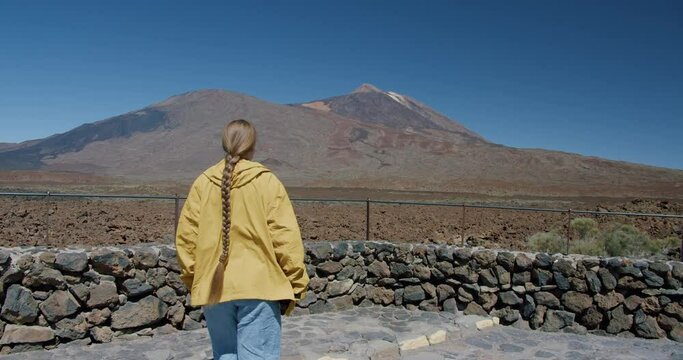 Female traveller looking at volcanic rocky landscape against teide mountain