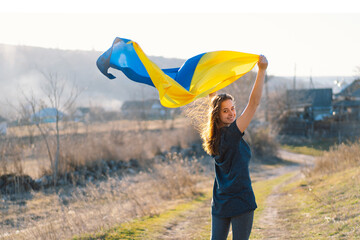 Woman holding a yellow and blue flag of Ukraine in outdoors. Independence Day. Flag Day....