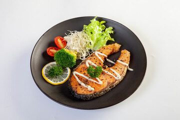 Salmon steak in a black plate