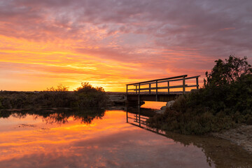 A vibrant sunrise reflecting on the Onkaparinga River in Port Noarlunga South Australia on March 4th 2022