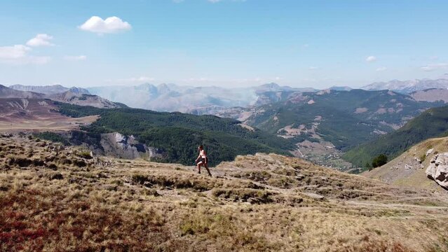 Woman Hikes Uphill a Mountain Trail in Prokletije National Park, Montenegro - Aerial Circling Pan