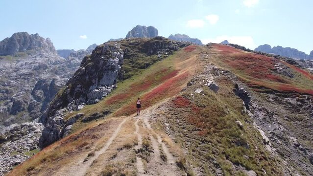 Woman Hikes a Mountain Ridge in Prokletije National Park, Montenegro - Aerial Circling Dolly