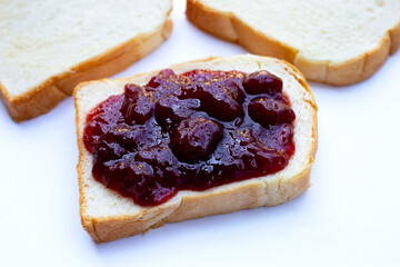 Bread with strawberry jam on white background