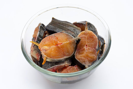 Catfish cut pieces in glass bowl on white background.