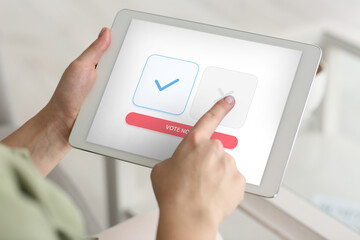 Young woman with tablet computer voting online, closeup