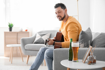 Handsome man playing guitar at home