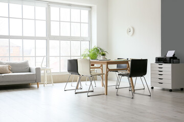 Interior of light conference hall with table, chairs and big window