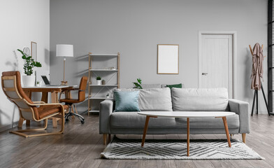 Interior of room with comfortable sofa, table and workplace