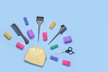 Composition with cosmetic bag, hairdresser's tools and curlers on blue background