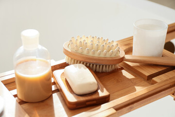 Bathtub tray with different supplies and cosmetic products, closeup