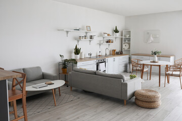Interior of stylish room with modern counters, sofas and table with laptop