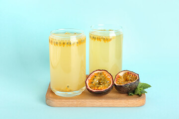 Glasses of delicious passion fruit juice on blue background
