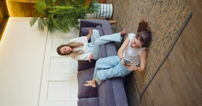 Vertical video of a mother scolds her daughter who constantly plays on her smartphone and does not respond to her mother's words. The concept of children's dependence on gadgets and social networks.