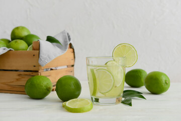 Glass of water with fresh limes on table